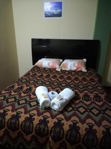 Una cama con dos toallas enrolladas. en Artesonraju Hostel Huaraz, en Huaraz