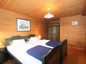 a bedroom with a large bed in a wooden room at Beautiful holiday apartment in a renovated farmhouse in Fresach Carinthia in Fresach