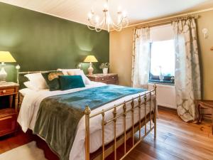 een slaapkamer met een bed en een groene muur bij Luring Holiday Home in Lierneux with Garden in Lierneux