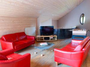 a living room with red furniture and a flat screen tv at Spacious Villa in Ovifat with Sauna in Ovifat