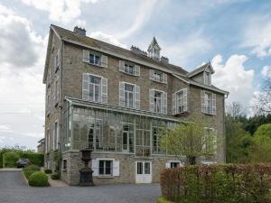 ein großes Backsteingebäude mit seitlichen Fenstern in der Unterkunft Beautiful manor house in a park near Rochefort in Forrières