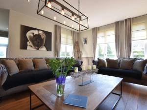een woonkamer met een bank en een tafel bij Mansion with Jacuzzi and swim pond in Lichtervelde