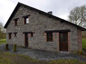 a stone house with a bunch of windows at Tranquil Holiday Home in Houffalize with Barbecue in Nadrin