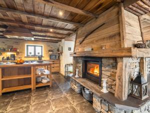 a stone fireplace in a kitchen with wooden ceilings at Home with Bubble Bath Sauna and Fireplace in Manhay