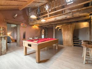 a ping pong table in a room with wooden ceilings at Home with Bubble Bath Sauna and Fireplace in Manhay