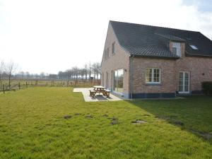 ein Backsteingebäude mit einem Picknicktisch auf einem Feld in der Unterkunft Soothing Holiday Home with Recreation Room in Sint-Amands