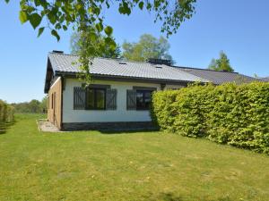 a white house with black windows and a hedge at Quaint Cottage in Mont near High Fens Nature Park in Malmedy