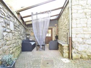 un patio con 2 sillas azules y una cortina en Charming gite in Les Avins situated by a stream, en Modave