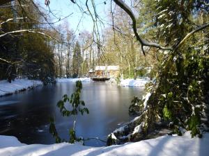 een huis aan de rivier in de sneeuw bij Delightful Chalet in Opglabbeek near Lake in Opglabbeek