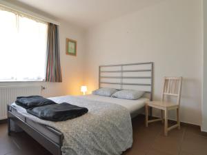 a bedroom with a large bed and a chair at Captivating Apartment in Halenfeld Amel with Terrace in Amblève