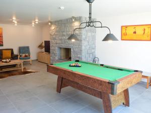 een woonkamer met een pooltafel en een open haard bij Tasteful Holiday Home in Waimes with Sauna in Ovifat