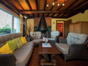 sala de estar con sofá, sillas y mesa en Open wooden chalet built against a hill, en Francorchamps