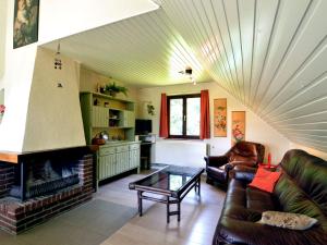 - un salon avec un canapé et une cheminée dans l'établissement Inviting chalet in the woods in Ovifat, à Waimes
