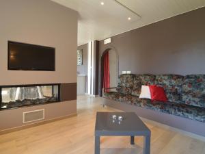 sala de estar con sofá y chimenea en Charming House With Sauna and Many Other Amenities, en Malmedy