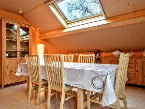 una sala da pranzo con tavolo, sedie e lucernario di Spacious Apartment in Malmedy with Garden a Malmedy