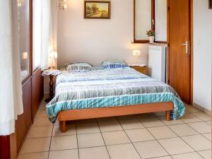 1 dormitorio con 1 cama con edredón azul y blanco en A small studio of a nature stone house, en Aywaille