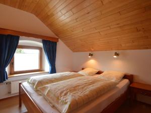 ビュートゲンバッハにあるLovely Holiday Home in B tgenbach by the Lakeの木製の天井のベッドルーム1室(大型ベッド1台付)