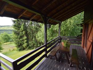 a wooden porch with a table and bench on it at Pretty cottage Ardennes near the Valley of Lesse in Vencimont