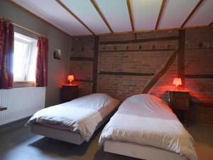 a bedroom with two beds and a brick wall at Wellness & Wilderness Libômont Escape in Waimes +30 photos