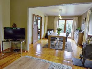 ein Wohnzimmer mit einem Tisch und einem TV in der Unterkunft Holiday Home in Chevron with Garden Terrace BBQ Parking in Neucy