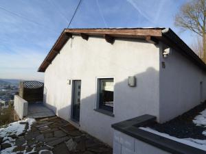 a small white house with a window on the side at Detached house with breathtaking views in Malmedy