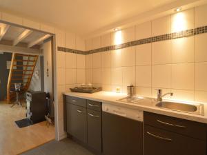uma cozinha com um lavatório e uma bancada em Contemporary Chalet in Malmedy near Forest em Malmedy