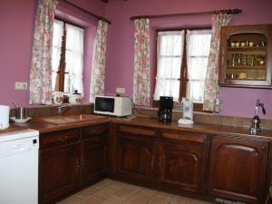 - une cuisine avec des murs violets, des placards en bois et un four micro-ondes dans l'établissement Vintage Villa in Ostuni Italy with Swimming Pool, à Bouillon