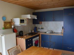 a small kitchen with blue cabinets and a sink at Apartment with private garden in the heights of Bouillon in Bouillon