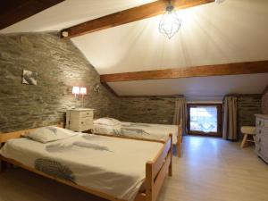 1 dormitorio con 2 camas y pared de piedra en Independant Gite at the Calm way in the Center, en Houffalize