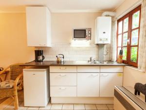 una cocina con armarios blancos y fregadero en Classy Apartment in Bohon with Garden, en Barvaux