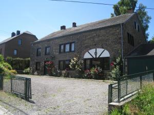 une maison en briques avec une arche devant elle dans l'établissement Cosy holiday house near La Roche, à Rendeux