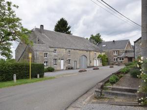 an empty road in front of a large stone house at Authentic Cottage in Weris with Private Garden in Weris
