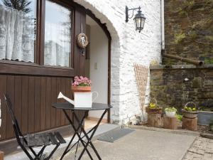 una mesa y una silla frente a una puerta en Former farmhouse in a quiet village, en Manhay