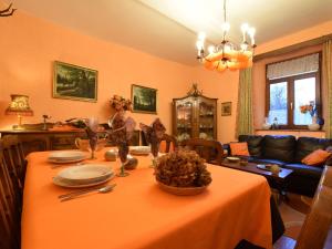 sala de estar con mesa y mantel naranja en holiday home in typical Ardennes style en Bérisménil