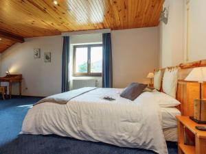 ラ・ロシュ・アン・アルデンヌにあるQuaint Holiday Home in Maboge with Saunaの木製の天井のベッドルーム1室(大型ベッド1台付)