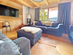 sala de estar con sofás azules y TV en A luxurious 12 person chalet with superb view en Les Collons