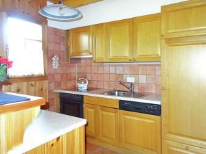 a kitchen with wooden cabinets and a sink at Comfortable Holiday Home with Fireplace in Vex in Les Collons