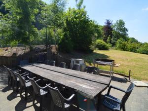 a large wooden table and chairs in a field at Lavish Holiday Home in Durbuy with Garden in Durbuy