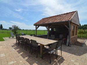 um pavilhão com uma mesa e cadeiras de madeira em Wonderful country house with huge garden em Roesbrugge-Haringe