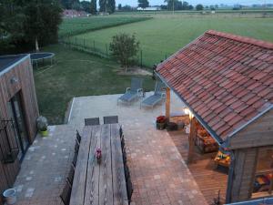 een patio met een houten bank bij Wonderful country house with huge garden in Roesbrugge-Haringe