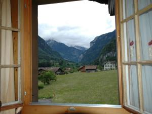 a window with a view of a field and mountains at Pristine home in a charming village large grassy sunbathing area view of the M nch and Jungfrau in Wilderswil