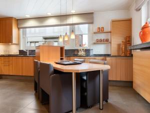 a kitchen with a wooden table and chairs at Elegant Holiday Home in De Panne with Sauna in De Panne