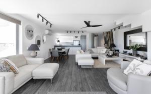 a living room with white furniture and a dining room at La Mer Apartment 8, Noosa Heads in Noosa Heads