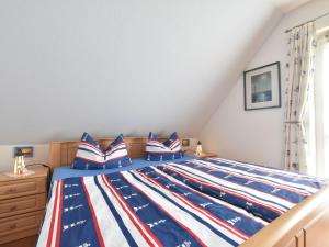 キュールングスボルンにあるLuxury apartment in Kuhlungsborn with huge terrace and gardenのベッドルーム1室(アメリカ旗製ベッド、青と白の枕付)