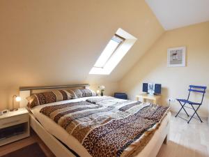 a bedroom with a large bed and a skylight at Pretty Apartment in Am Salzhaff with Fireplace in Rakow