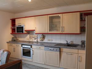 a kitchen with wooden cabinets and a sink at Pleasant Apartment in Kropelin With Terrace in Kröpelin