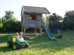 two children riding on a toy truck in front of a play house at Quaint Apartment in Semlow Germany with Garden in Semlow