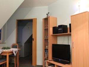 a living room with a tv and a dining room table with a table at Cozy Apartment in Boltenhagen near Seabeach in Boltenhagen