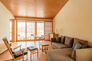 NISEKO Inn of Youtei Raku Suisan في كوتشان: غرفة معيشة مع أريكة وطاولة