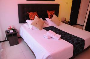 duas camas num quarto de hotel com almofadas cor-de-rosa em Central House Hotel em Bogotá